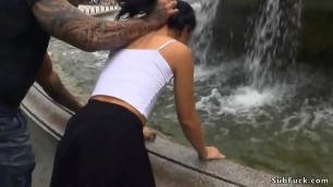 Slim brunette wet at public fountain